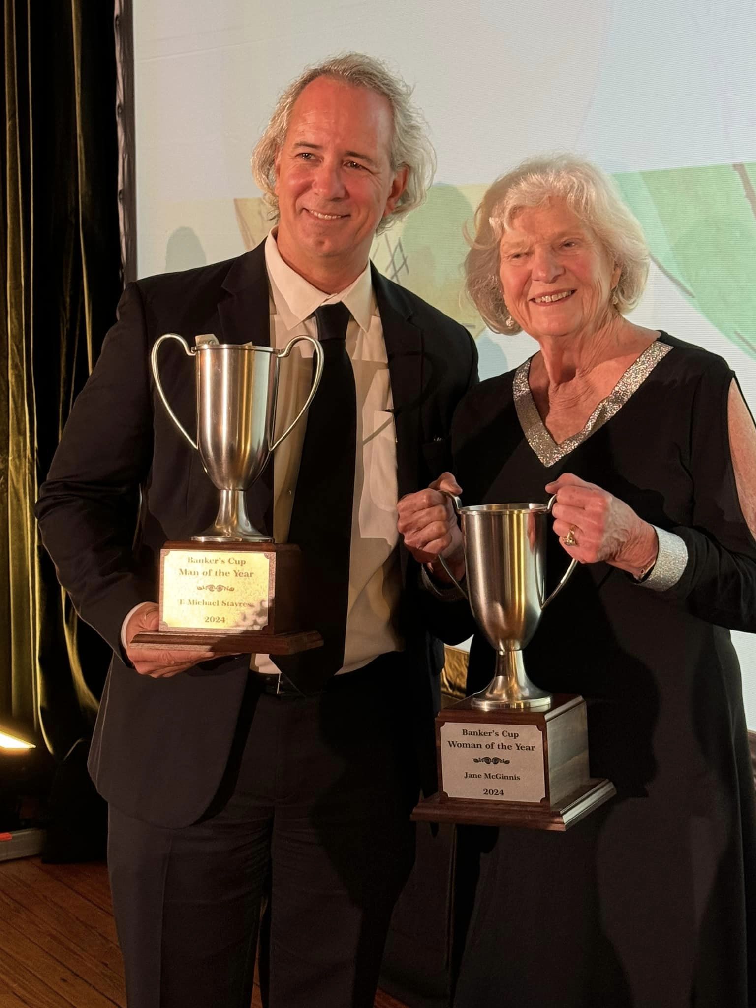 T. Michael Stavres and Jane McGinnis pose with their Banker's Cup trophies. 